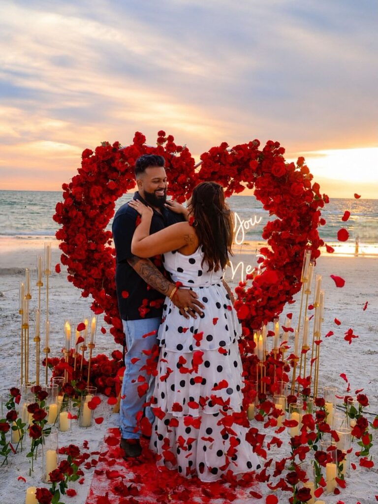 Couple celebrating a beach proposal at sunset
