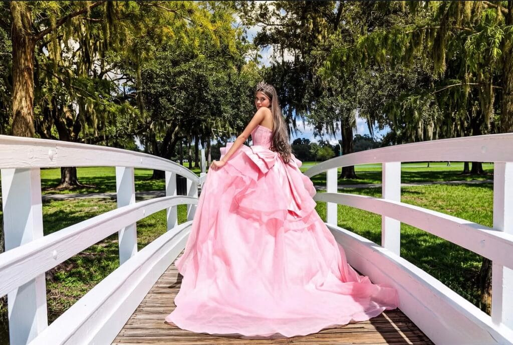 Quinceañera in a formal gown surrounded by floral decor